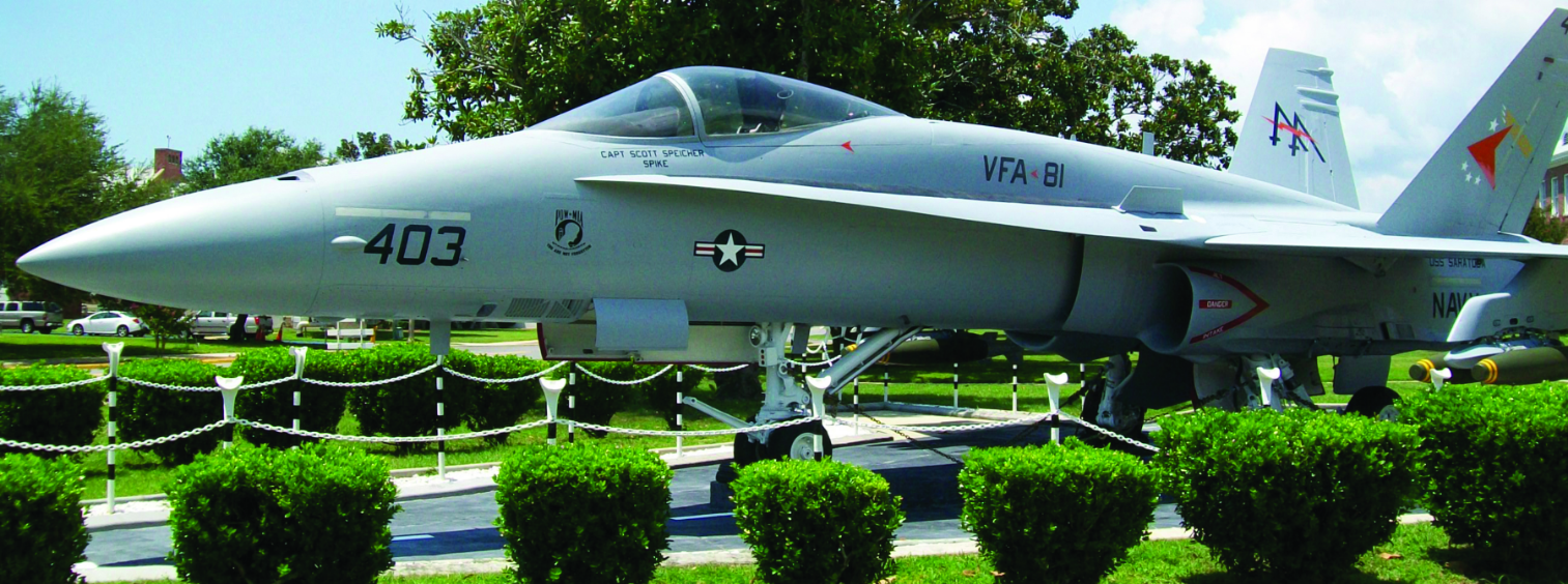 An F/A-18 Hornet fighter jet, tail number 403, on static display at NAS Pensacola, dedicated to Captain Scott Spike Speicher.